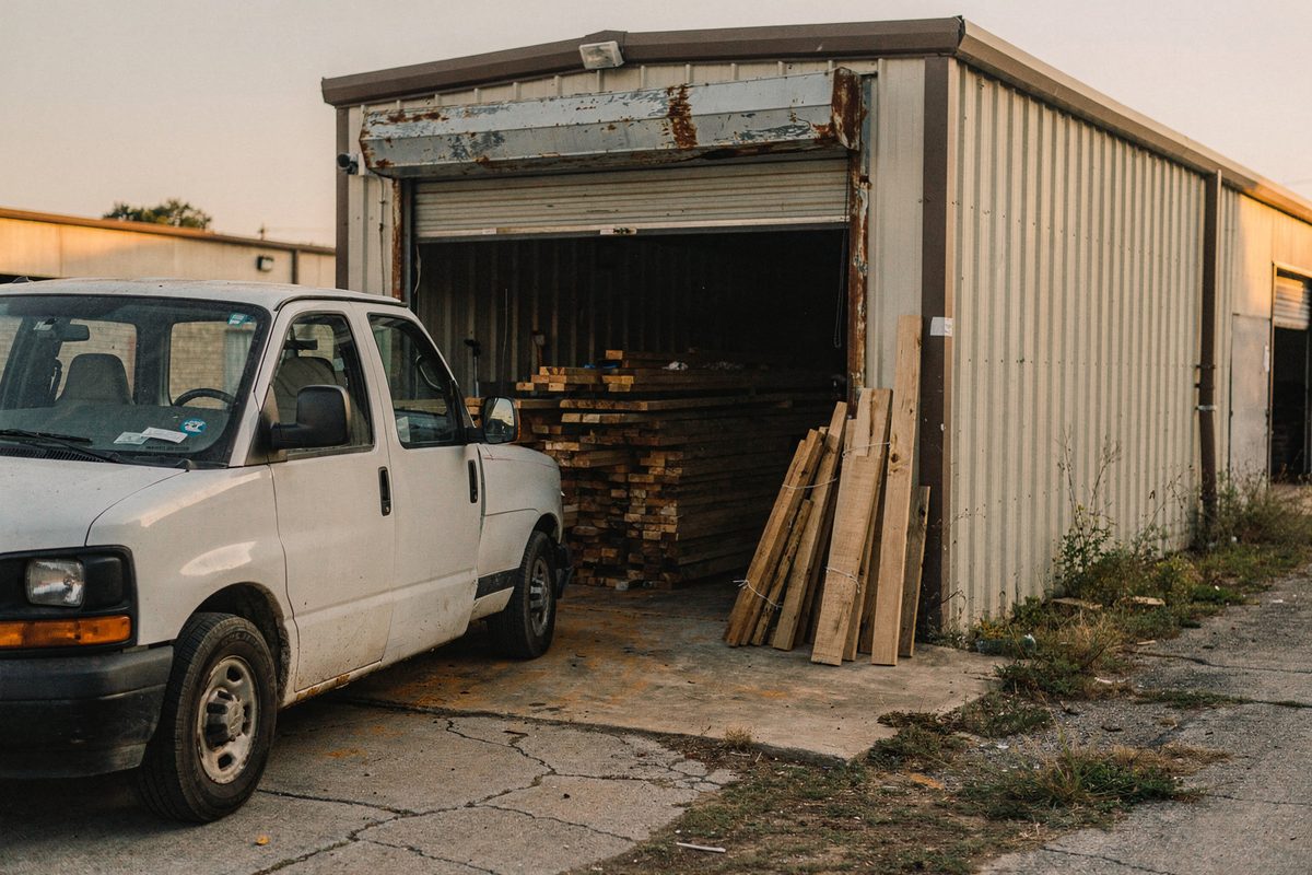 Ronevexa shop bay exterior with the roll-up door open and the van parked outside